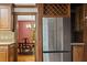 Kitchen featuring stainless refrigerator, wood cabinets, tile backsplash, and view into dining room at 5125 Penny Rd, Raleigh, NC 27606