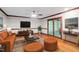 Inviting living room with hardwood floors, neutral walls, a plush orange sofa, and large glass doors to screened porch at 5125 Penny Rd, Raleigh, NC 27606