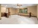 Spacious living room featuring neutral carpet, a wet bar, and natural light through a window at 5125 Penny Rd, Raleigh, NC 27606