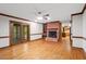 Cozy living room featuring wood floors, a brick fireplace, and glass doors leading to the outside at 5125 Penny Rd, Raleigh, NC 27606