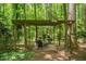 Inviting outdoor pergola with seating and a fire pit nestled amongst mature trees for an escape to your backyard at 5125 Penny Rd, Raleigh, NC 27606