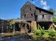 Historic watermill with a large wooden water wheel and stone foundation providing a glimpse into the past at 5125 Penny Rd, Raleigh, NC 27606