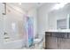 Bathroom features a shower-tub combo, blue shower curtain, and vanity with a dark cabinet at 5420 Mill Dam Rd, Wake Forest, NC 27587