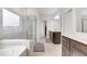 Modern bathroom with double vanity, glass shower, soaking tub, neutral tile, and natural light at 5420 Mill Dam Rd, Wake Forest, NC 27587