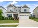 Charming two-story home showcasing a two-car garage, lush landscaping, and inviting curb appeal at 5420 Mill Dam Rd, Wake Forest, NC 27587