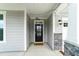 Welcoming front entrance with a stylish black door, stone pillars, and a cozy covered porch at 5420 Mill Dam Rd, Wake Forest, NC 27587