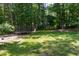 Large backyard featuring a swing set, trampoline, lush green grass, and mature trees, ideal for play and relaxation at 5917 Clearsprings Dr, Wake Forest, NC 27587