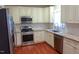 Modern kitchen featuring stainless steel appliances, granite countertops, white cabinets, and beautiful hardwood floors at 5917 Clearsprings Dr, Wake Forest, NC 27587