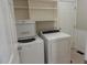 Convenient laundry room with modern washer and dryer units, storage shelves, and tiled floor at 5917 Clearsprings Dr, Wake Forest, NC 27587
