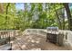 Back deck featuring a gas grill, outdoor seating, and lush green trees at 6 Weathergreen Ct, Durham, NC 27713