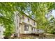 Exterior view of the back of the home showing its deck and lush green trees at 6 Weathergreen Ct, Durham, NC 27713
