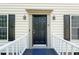Inviting front door with sidelights, framed by a porch, and enhanced with decorative lanterns at 6 Weathergreen Ct, Durham, NC 27713