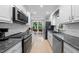 Well-lit kitchen with stainless steel appliances, white cabinets, and black marbled countertops at 6 Weathergreen Ct, Durham, NC 27713