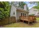 Exterior backyard view featuring deck, fenced yard, and well-maintained lawn at 6004 Volant Dr, Raleigh, NC 27609