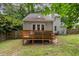 Backyard featuring deck with outdoor seating, fenced yard, and well-maintained lawn at 6004 Volant Dr, Raleigh, NC 27609