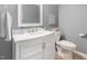 Bathroom with a marble vanity and sink, a decorative mirror, and modern fixtures at 6004 Volant Dr, Raleigh, NC 27609