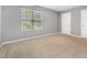 Spacious bedroom featuring neutral walls, carpet, and a bright window at 6004 Volant Dr, Raleigh, NC 27609