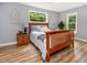 Cozy bedroom featuring hardwood floors, a wood-frame bed, and natural light at 6004 Volant Dr, Raleigh, NC 27609