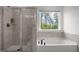 Bright bathroom with a separate glass shower and tub, complemented by a lovely window view at 601 Lauren Ann Dr, Apex, NC 27523