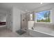 Contemporary bathroom featuring a glass-enclosed shower, a tub, and a scenic window view at 601 Lauren Ann Dr, Apex, NC 27523
