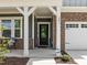 Charming front porch with chairs, white columns, brick accents, and a well-manicured yard at 601 Lauren Ann Dr, Apex, NC 27523