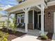 Charming front porch with chairs, white columns, brick accents, and a well-manicured yard at 601 Lauren Ann Dr, Apex, NC 27523