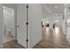 Hallway with wood floors leads to a bathroom and an open concept living and dining area at 601 Lauren Ann Dr, Apex, NC 27523