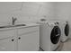 Well-equipped laundry room features a sink, counter space, and modern washer and dryer for convenience at 601 Lauren Ann Dr, Apex, NC 27523