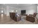 Living room with wood floors and recliner seating area is open to the dining area at 601 Lauren Ann Dr, Apex, NC 27523