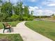 Scenic view of a community park area with a paved walking path and bench seating at 601 Lauren Ann Dr, Apex, NC 27523