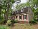 Beautiful two-story home featuring dormer windows, red shutters, and a manicured lawn at 702 Longleaf Dr, Chapel Hill, NC 27517