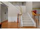 Bright foyer with hardwood floors, staircase with white railings, and decorative wainscoting at 708 Cheselden Dr, Durham, NC 27713