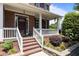 Inviting brick home featuring a covered front porch with white columns and a well-manicured garden at 708 Cheselden Dr, Durham, NC 27713