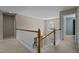 Hallway with staircase featuring wooden banister, neutral walls, and a window that provides natural light at 708 Cheselden Dr, Durham, NC 27713