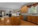 Charming kitchen with stainless dishwasher, wood cabinetry, island, and an open view to living room at 708 Cheselden Dr, Durham, NC 27713