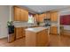 Spacious kitchen with wood cabinets, island, stainless steel appliances, and hardwood flooring at 708 Cheselden Dr, Durham, NC 27713