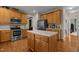 Open kitchen featuring an island, stainless appliances, ample wood cabinetry, and hardwood floors at 708 Cheselden Dr, Durham, NC 27713