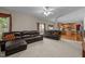 Open concept living room area with plush carpet, brown leather sofas, and access to the kitchen space at 708 Cheselden Dr, Durham, NC 27713