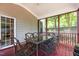 Inviting screened porch with outdoor dining set, offering a cozy space for enjoying meals and nature at 708 Cheselden Dr, Durham, NC 27713