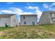 A view of backyards showcasing home exteriors, green grass, and a bright blue sky with fluffy clouds at 717 Little Patch St, Zebulon, NC 27597
