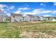 Expansive backyard showcasing multiple homes, lush green grass, and a bright blue sky at 717 Little Patch St, Zebulon, NC 27597
