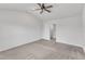 Spacious bedroom with ceiling fan, plush carpeting, and view into the bathroom at 717 Little Patch St, Zebulon, NC 27597