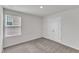 Cozy bedroom showcasing a window with blinds, plush carpet, and a double-door closet at 717 Little Patch St, Zebulon, NC 27597