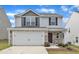 Two-story home with a two-car garage, stone accents, and vinyl siding for a modern look at 717 Little Patch St, Zebulon, NC 27597