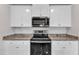 Modern kitchen with granite counters, stainless appliances, and white cabinets at 717 Little Patch St, Zebulon, NC 27597