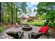 Backyard stone fire pit with seating, overlooking a beautiful two-story brick house at 7932 Twin Pines Way, Fuquay Varina, NC 27526