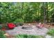 Outdoor patio with fire pit area surrounded by chairs and lush trees at 7932 Twin Pines Way, Fuquay Varina, NC 27526