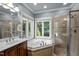 Spacious bathroom with soaking tub, glass-enclosed shower and natural light from multiple windows at 7932 Twin Pines Way, Fuquay Varina, NC 27526