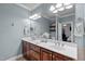 Bathroom featuring a double sink vanity with marble countertops and warm wood cabinets and decorative lighting at 7932 Twin Pines Way, Fuquay Varina, NC 27526