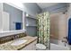 Bathroom featuring a large sink vanity, granite countertops, tropical shower curtain, and linen closet at 7932 Twin Pines Way, Fuquay Varina, NC 27526